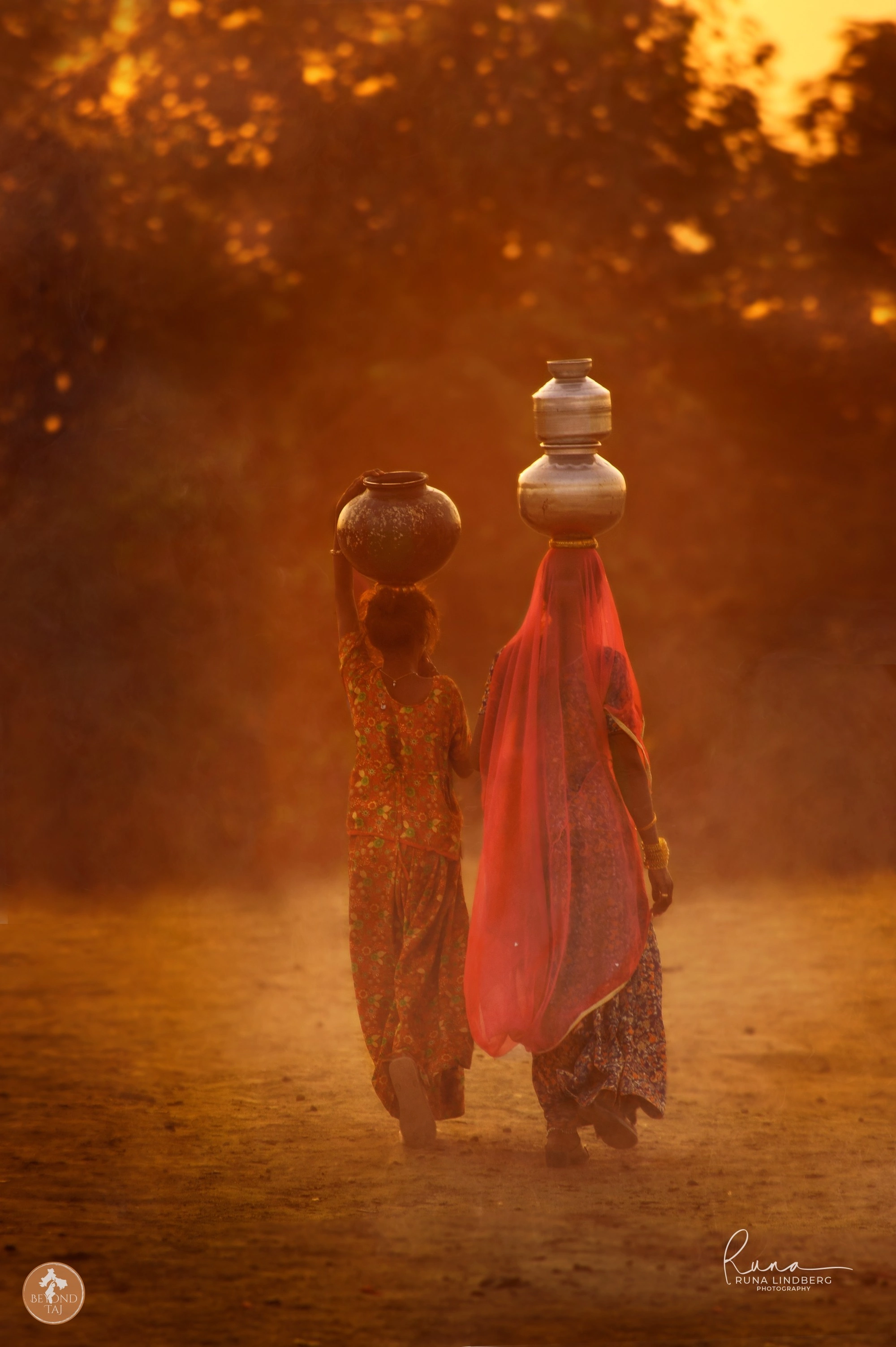 Rajasthani women carrying brass water pots at golden hour