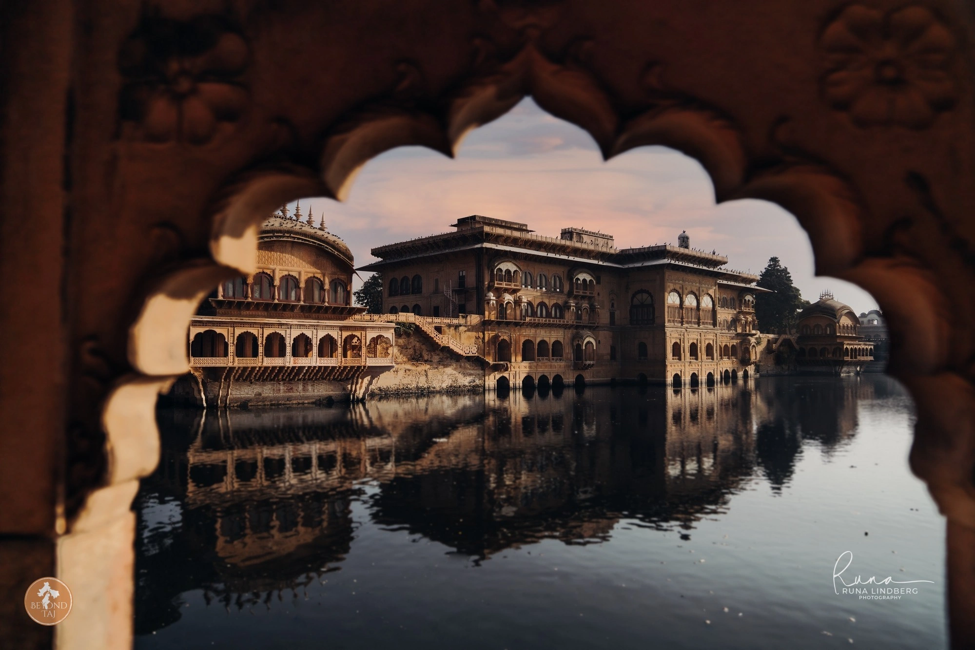 Deeg Palace reflected in water, framed by a scalloped archway