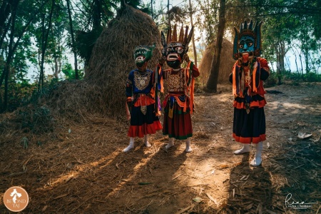 Group of Gomira dancers beside village haystacks