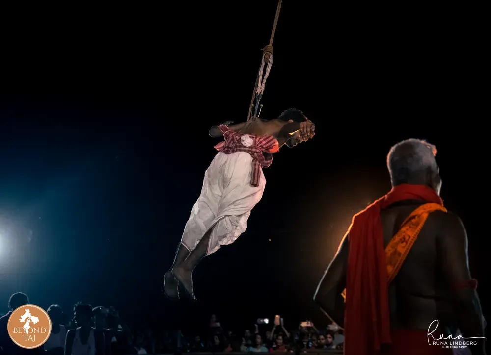 man hanging on the hooks swinging through the night sky